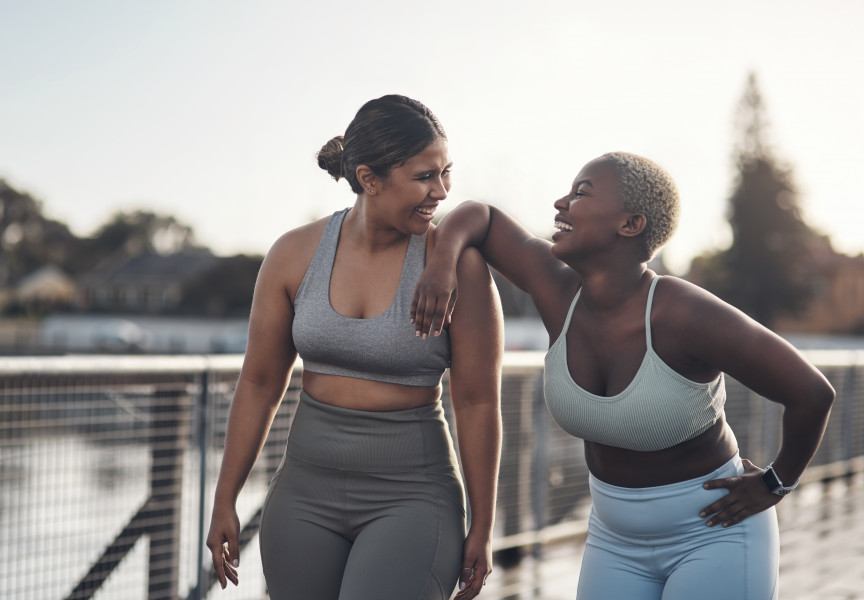 two women in workout clothes laughing